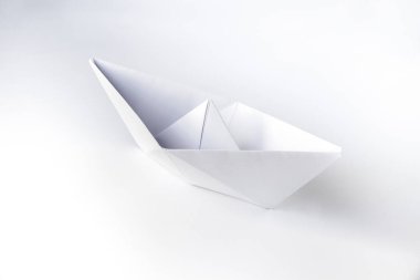 Kağıt tekne origamisi boş bir arkaplanda izole edildi.