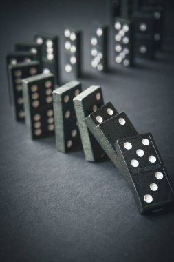 Arka planda siyah domino taşları zinciri. Domino etkisi kavramı