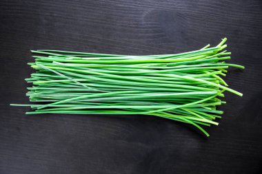 Bunch of fresh chives isolated on black background