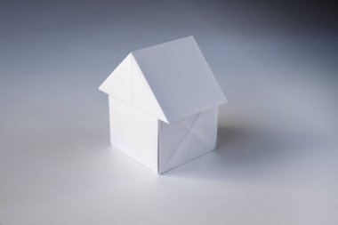 Kağıt ev origamisi boş beyaz bir arkaplanda izole edildi.