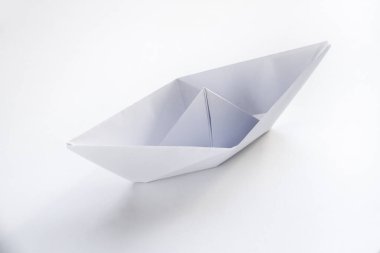 Kağıt tekne origamisi boş bir arkaplanda izole edildi.
