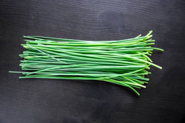 Bunch of fresh chives isolated on black background