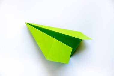 Yeşil kağıt uçak origamisi boş beyaz bir arkaplanda izole edildi
