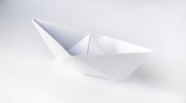 Kağıt tekne origamisi boş bir arkaplanda izole edildi.