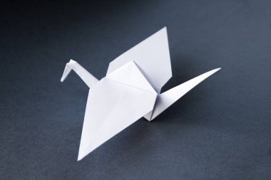 Beyaz kağıt turna origamisi boş gri bir arkaplanda izole edildi.