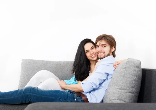 Jeune couple assis sur un canapé — Photo