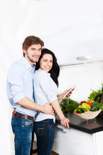Couple at their kitchen home happy smile cooking — Stock Photo, Image