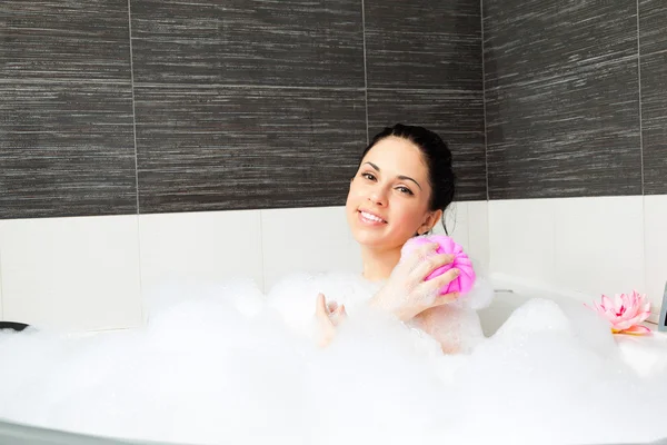 Hermosa sonrisa mujer lavando hombro con esponja rosa — Foto de Stock