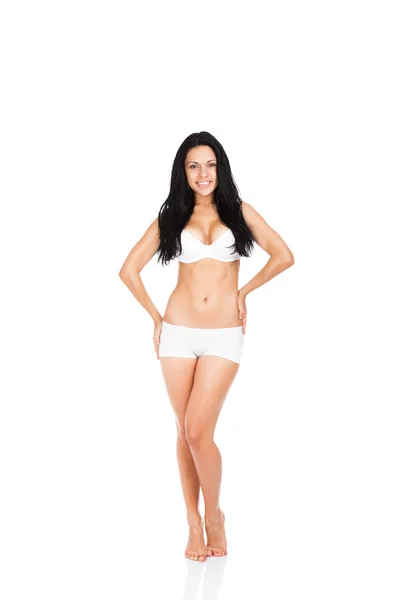 Kobieta kontroli żołądka brzuch cellulit talii, uśmiechając się pełnej długości na białym tle — Zdjęcie stockowe