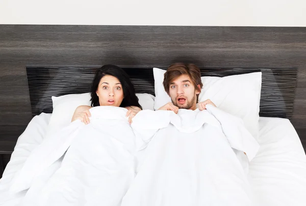 Unglückliches Überraschungspaar liegt im Bett — Stockfoto