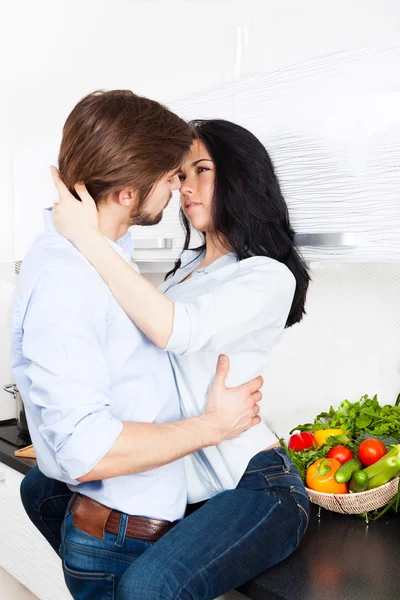 Paar sinnliche Küsse in ihrer Küche zu Hause — Stockfoto