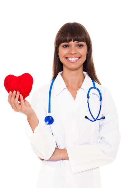 Женщина-врач со стетоскопом держит красное сердце — стоковое фото