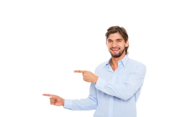 Guapo joven hombre de negocios feliz sonrisa señalar el dedo al espacio de copia vacía —  Fotos de Stock