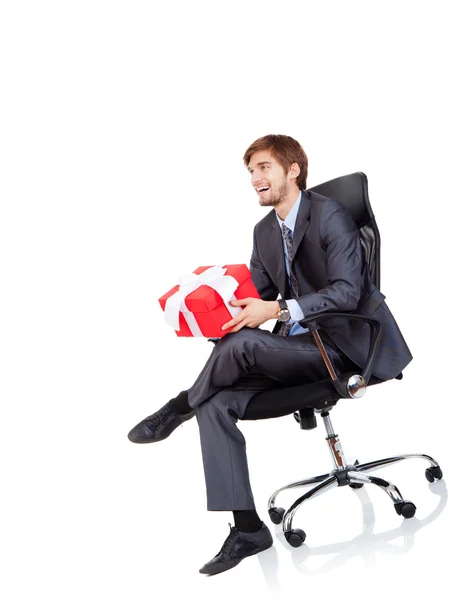 Business man hold gift box in chair — Stock Photo, Image