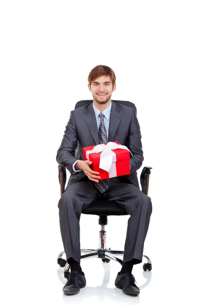 Business man hold gift box in chair — Stock Photo, Image