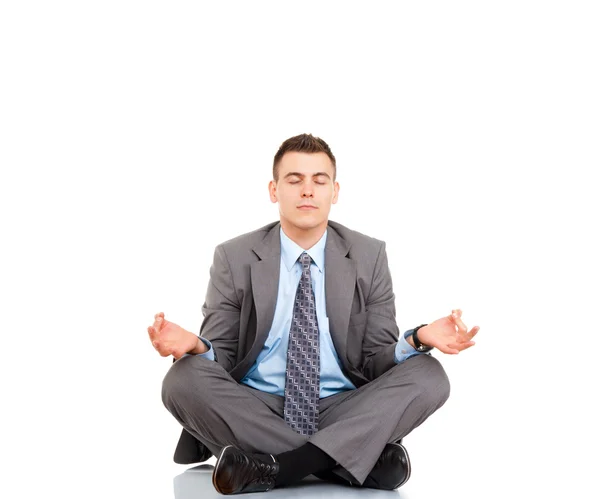 Businessman with eyes closed sitting in lotus position — Stock Photo, Image