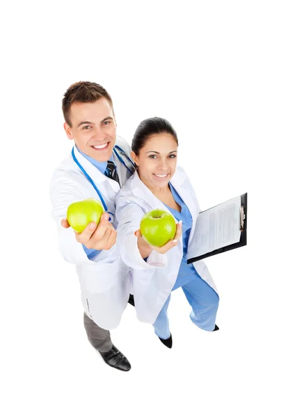 Doktor erkek ve kadın mutlu tutun yeşil taze elma gülümse — Stok fotoğraf