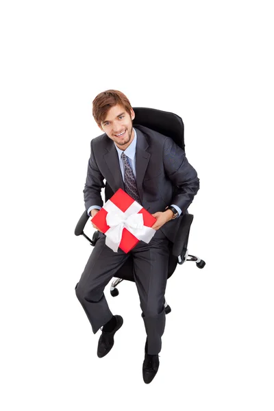 Geschäftsmann hält Geschenkbox im Stuhl — Stockfoto