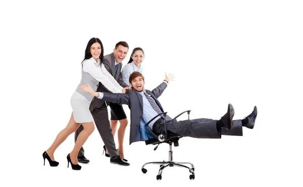 Excited Business people push colleague sitting in chair — Stock Photo, Image