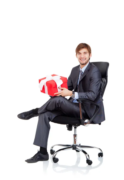 Business man hold gift box in chair — Stock Photo, Image