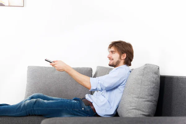 Homem assistindo tv segurar controle remoto — Fotografia de Stock