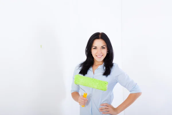 Mulher sorrir pintura na cor verde casa parede branca — Fotografia de Stock