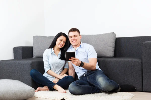 Pareja joven feliz olor usando tableta pantalla táctil almohadilla en casa — Foto de Stock