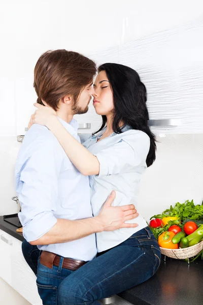 Couple kissing at their kitchen — Stock Photo, Image