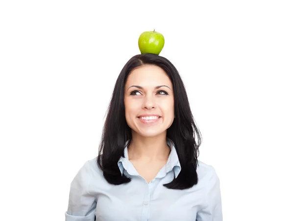 Молодая женщина держит зеленое свежее яблоко на голове — стоковое фото