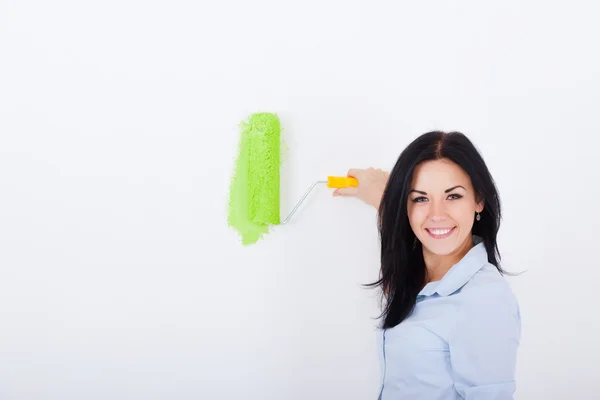 Mujer pintura en color verde pared blanca — Foto de Stock