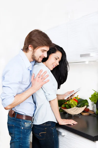 Ehepaar nutzt elektronisches Tablet in der Küche — Stockfoto