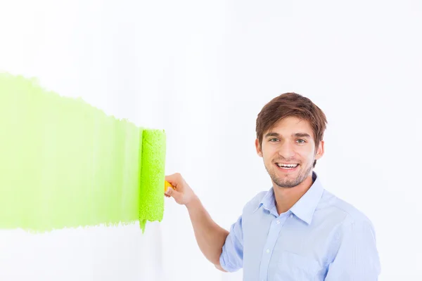 Homem pintar na parede branca cor verde — Fotografia de Stock
