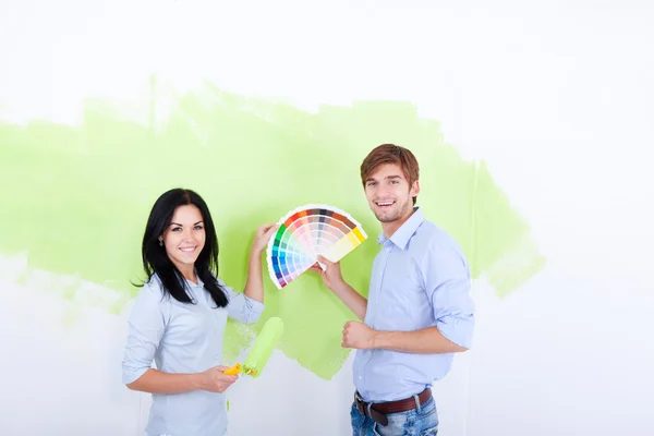 Pintura de pareja en color verde pared blanca — Foto de Stock