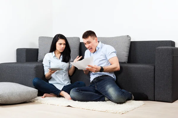 Ongelukkige paar lezen van een brief in de woonkamer-geld probleem concept — Stockfoto