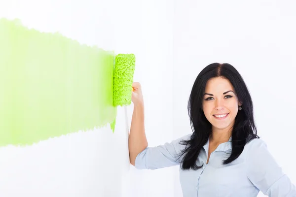 Kvinnan ler färg i grön färg vit vägg — Stockfoto
