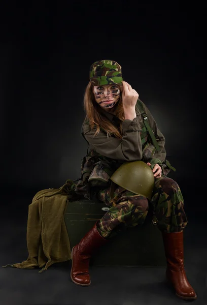 Soldier woman sitting hold helmet — Stock Photo, Image