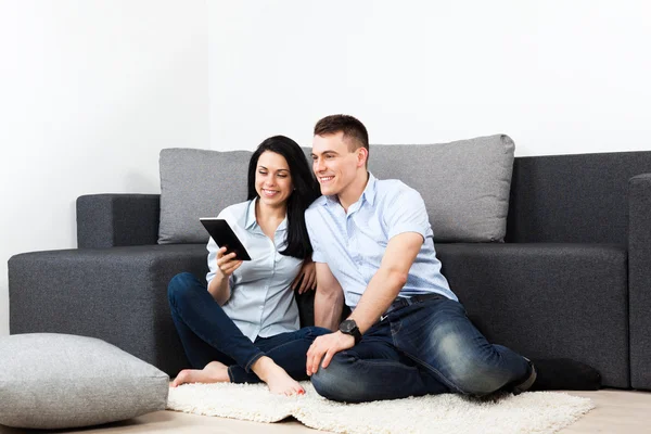 Pareja joven feliz olor usando tableta pantalla táctil almohadilla en casa —  Fotos de Stock