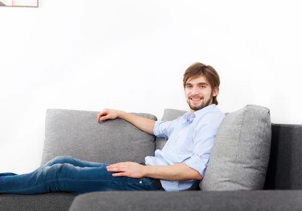 Jonge man ontspannen liggend op de Bank — Stockfoto