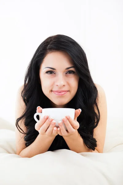Mooie jonge vrouw houd kopje koffie denk ontspannen liggend op de Bank — Stockfoto
