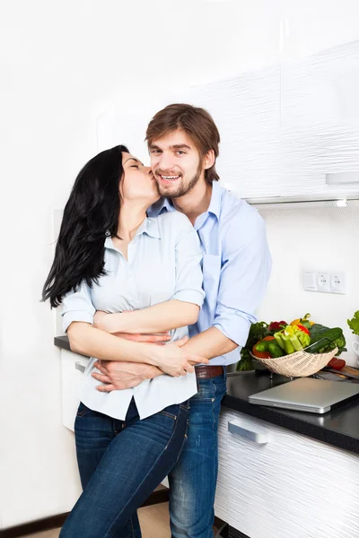 Pareja besándose en su cocina — Foto de Stock