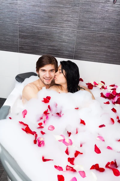 Young happy couple lying in jacuzzi — Stock Photo, Image