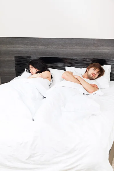 Несчастная пара, лежащая в постели — стоковое фото
