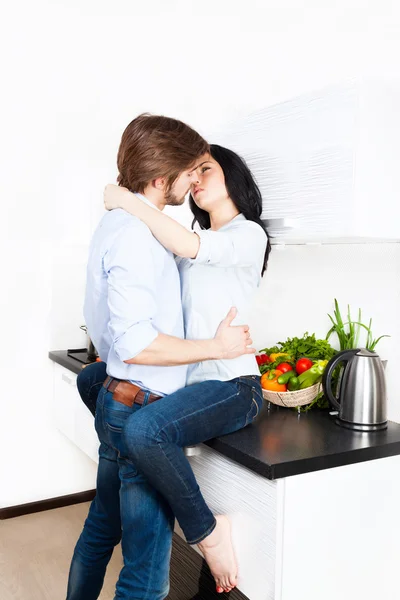 Casal beijando em sua cozinha — Fotografia de Stock