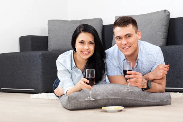 Jovem casal bebendo vinho tinto comemorando — Fotografia de Stock