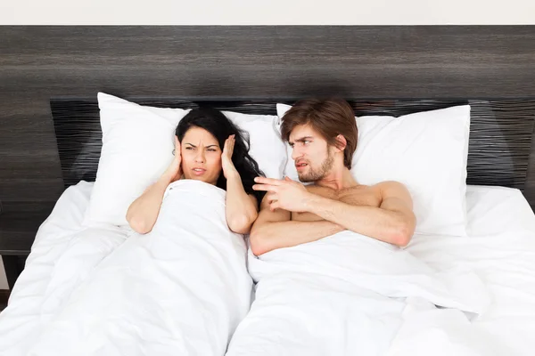Unhappy couple lying in a bed — Stock Photo, Image