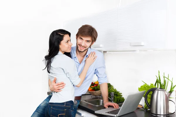 Pareja usando portátil en su cocina — Foto de Stock