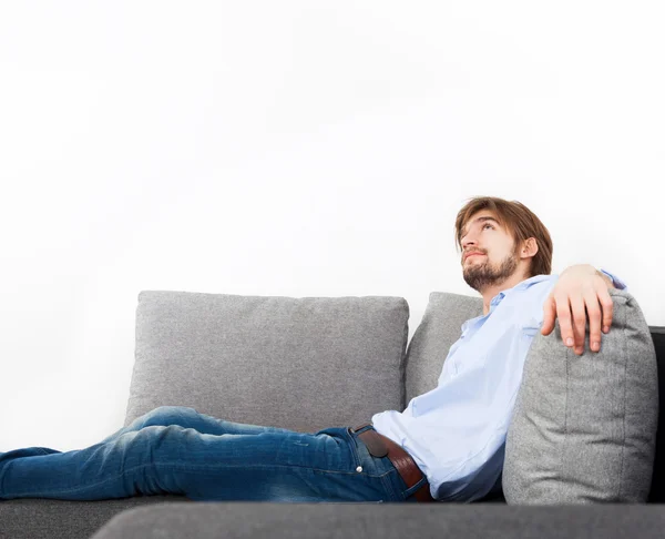 Mladý muž ležel na gauči relaxační — Stock fotografie