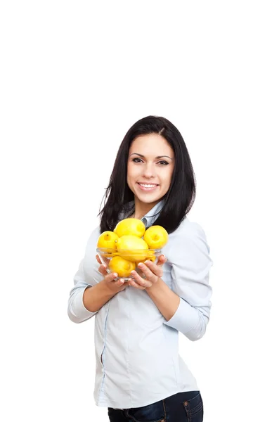 Молодая женщина держит чашу, полную лимонов — стоковое фото