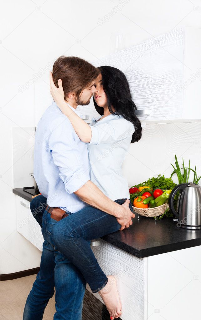 Couple kissing at their kitchen