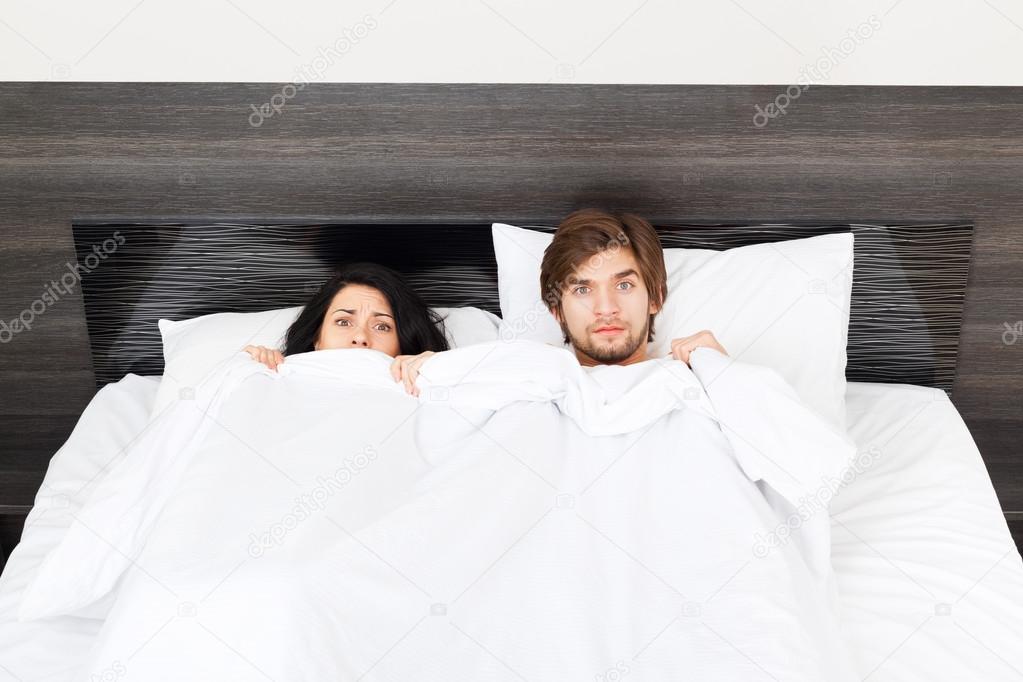 Surprise couple lying in a bed